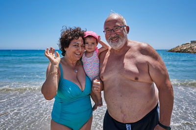 A couple of grandparents with their granddaughter on vacation at the beach. vacation concept