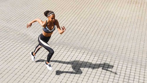 High angle view of young woman running on street