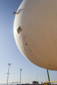 Low angle view of airplane flying against clear blue sky