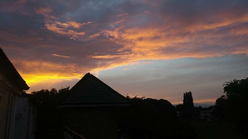 Silhouette of building against cloudy sky