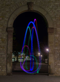 Illuminated light painting on wall at night