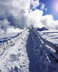 Scenic view of snow covered mountain against cloudy sky