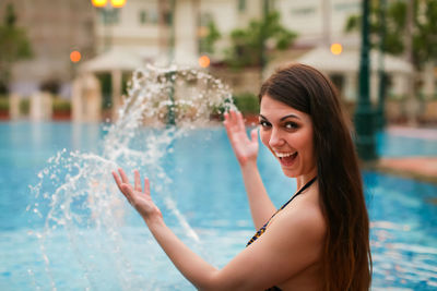 Portrait of a smiling young woman in swimming pool