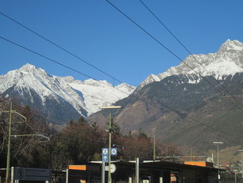 Ski lift over mountains against clear sky