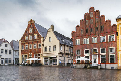 Buildings by canal against sky