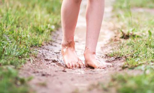 Low section of woman standing on field