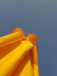 Low angle view of yellow against blue sky