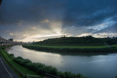 Scenic view of river against cloudy sky