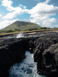 Scenic view of rocks in sea against sky