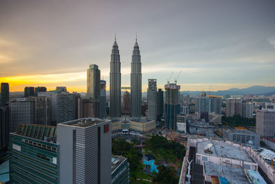 Aerial view of cityscape against cloudy sky