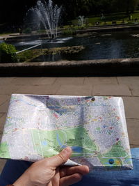 Midsection of person holding umbrella by lake