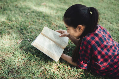 High angle view of woman sitting on book