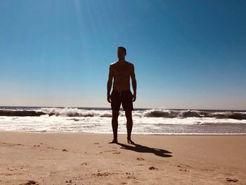 Rear view of man standing on beach