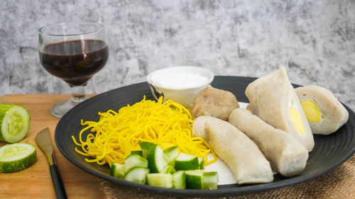 Various fruits in plate on table