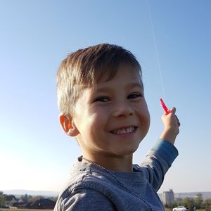 Portrait of smiling boy against sky