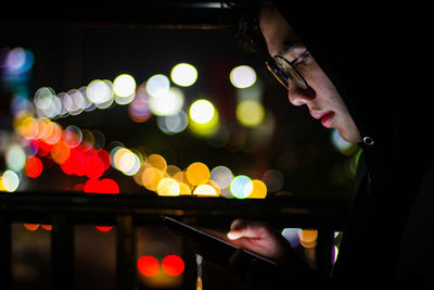 Midsection of man using smart phone at night