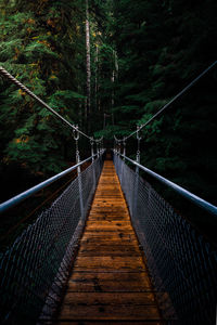 Rear view of man walking on footbridge