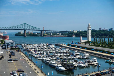 View of yachts moored in marina with bridge in the background
