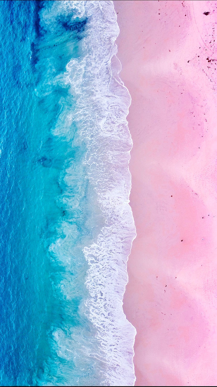 HIGH ANGLE VIEW OF WAVES BREAKING ON BEACH