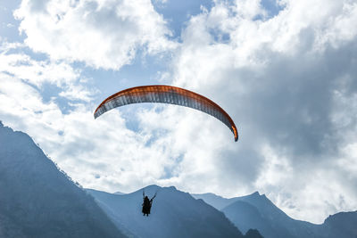 Person paragliding against sky