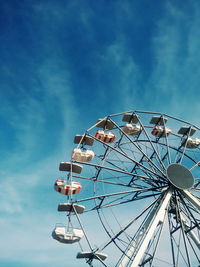 Low angle view of ferris wheel against blue sky