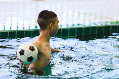 Full length of shirtless boy swimming in pool