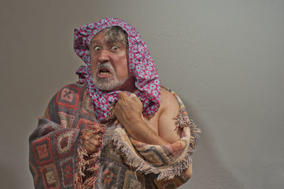 Midsection of man wearing hat against wall