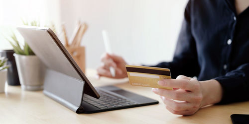 Midsection of woman using laptop on table