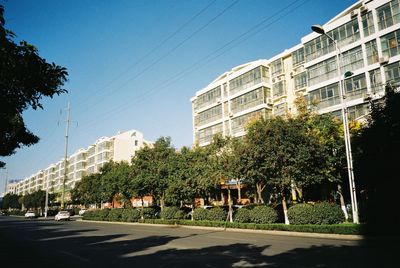 Street by buildings against clear sky