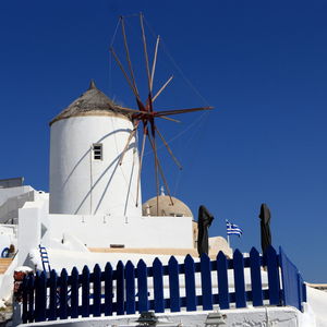 Low angle view of windmill against clear blue sky