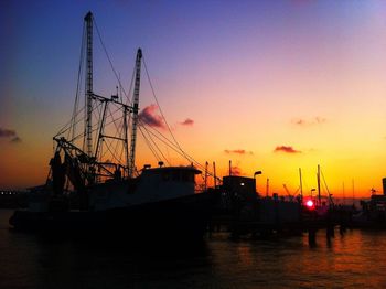 Silhouette of boats at harbor during sunset