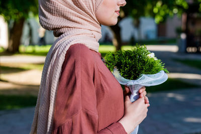 Midsection of woman holding umbrella standing outdoors