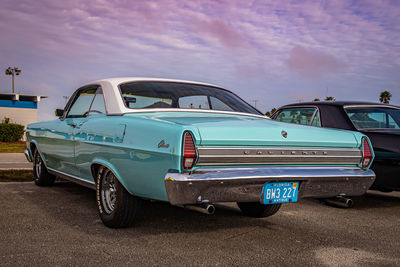 Side view of old car on road against blue sky