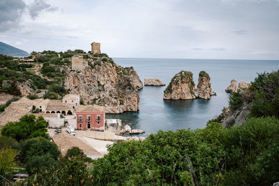 Scenic view of sea by buildings against sky