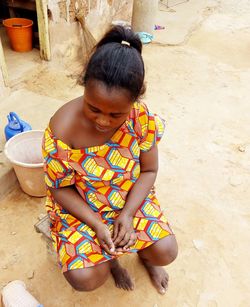 High angle view of girl sitting outdoors