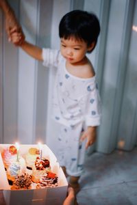 High angle view of cute girl playing with birthday cake