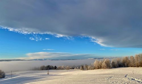 Scenic view of snowy field against sky