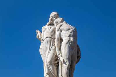 Low angle view of statue against clear blue sky