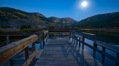 Scenic view of lake against clear blue sky at night