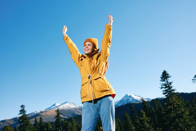 Young woman standing against mountain