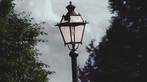 Low angle view of street light against cloudy sky