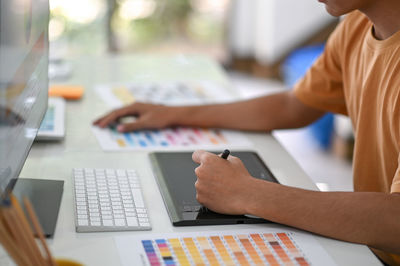 Midsection of man using laptop on table