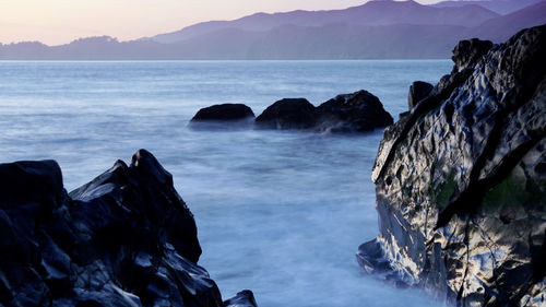 Scenic view of rocks in sea against sky