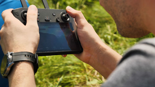 Cropped hand of man holding camera