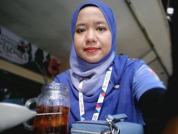 Portrait of woman in hijab with food