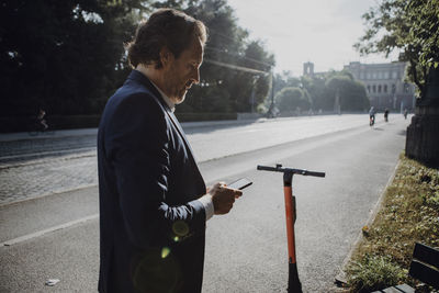 Businessman with e-scooter in the city