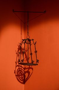 Close-up of electric lamp against orange wall