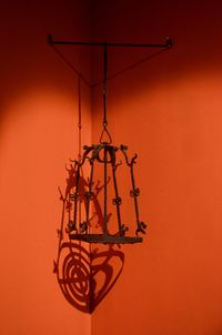 Close-up of electric lamp against orange wall