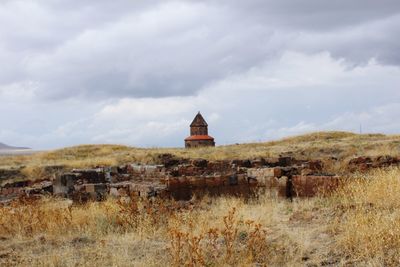 Traditional building on field against sky