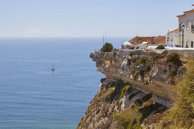 Scenic view of sea by buildings against sky